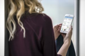 woman with brown blouse looking at phone screen