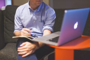 man seated with open laptop on table