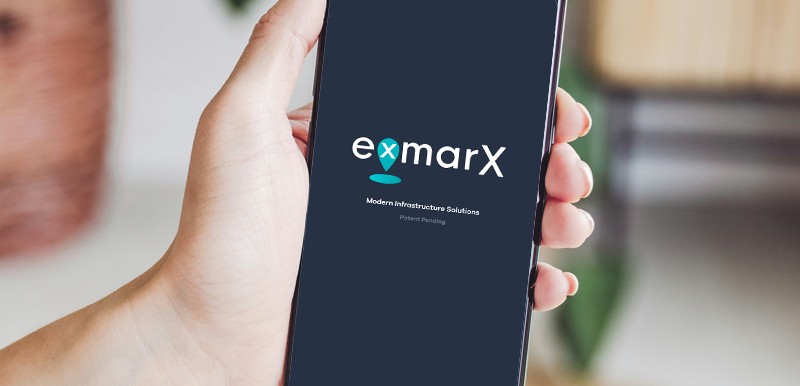 A hand holding an android phone with a screen showing the eXmarX mobile app logo